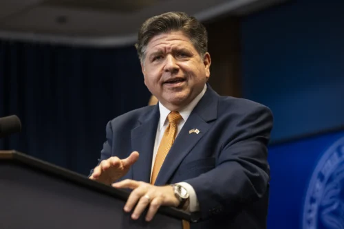 JB Pritzker speaking at a podium.